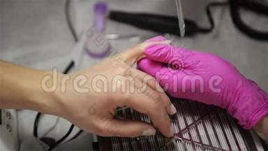 美容师在美容沙龙里为一个美容师磨指甲吧。 手指指甲处理、研磨和抛光